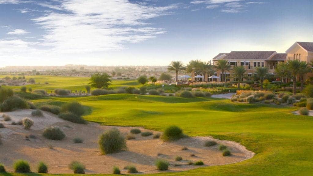 Arabian Ranches Golf Club shown during sunset with trees, bunkers and more on display.