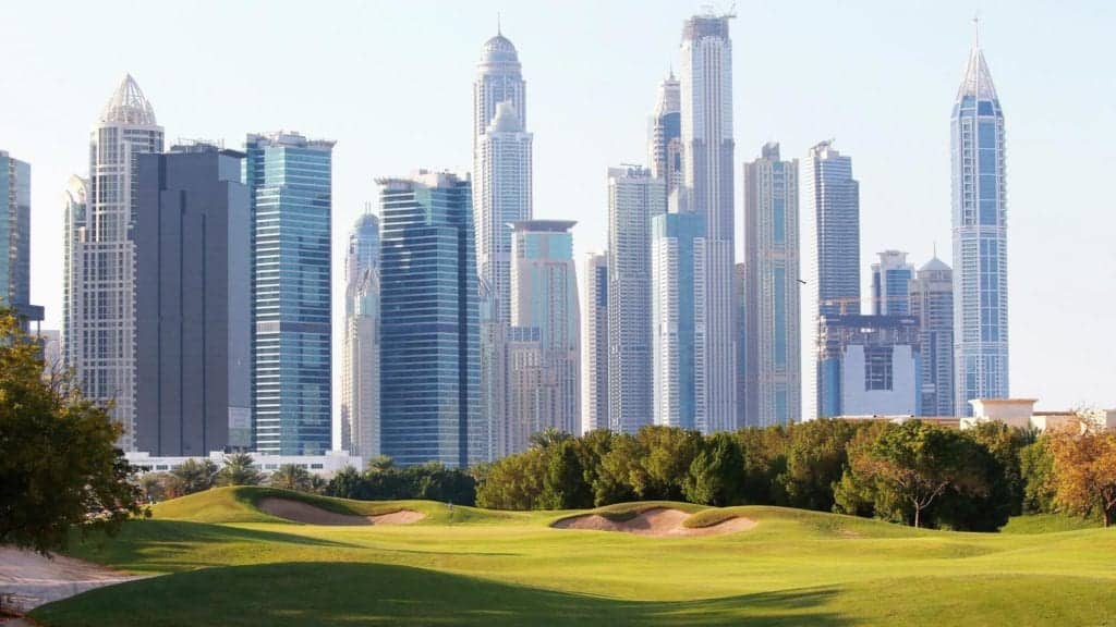 Flera höghus bakom en grön golfbana i Dubai.
