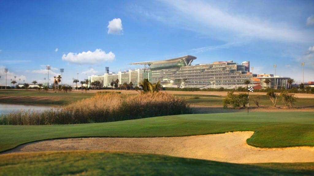 The Track, Meydan Golf with dubai skyline in the background and people playing golf.