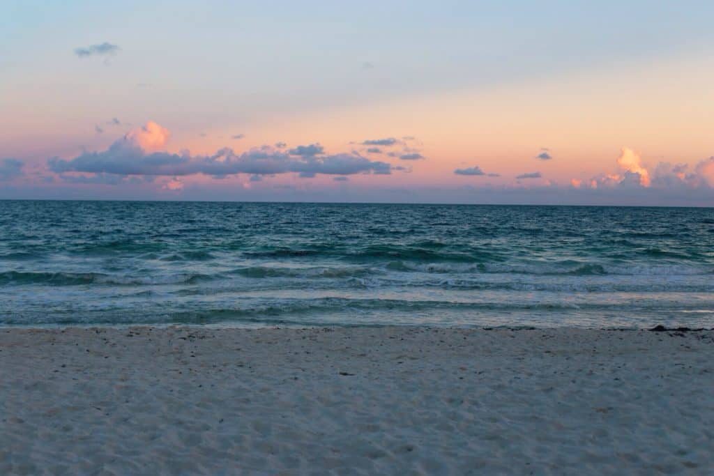 Strand solnedgång vatten sand.