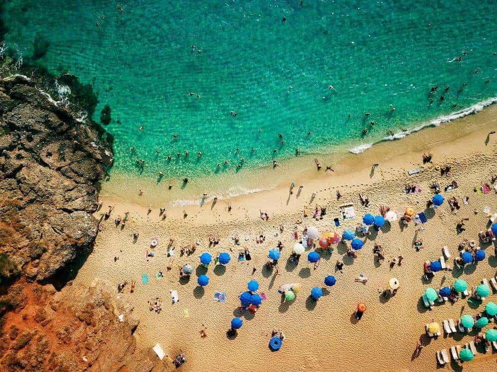 Turister badar på strand