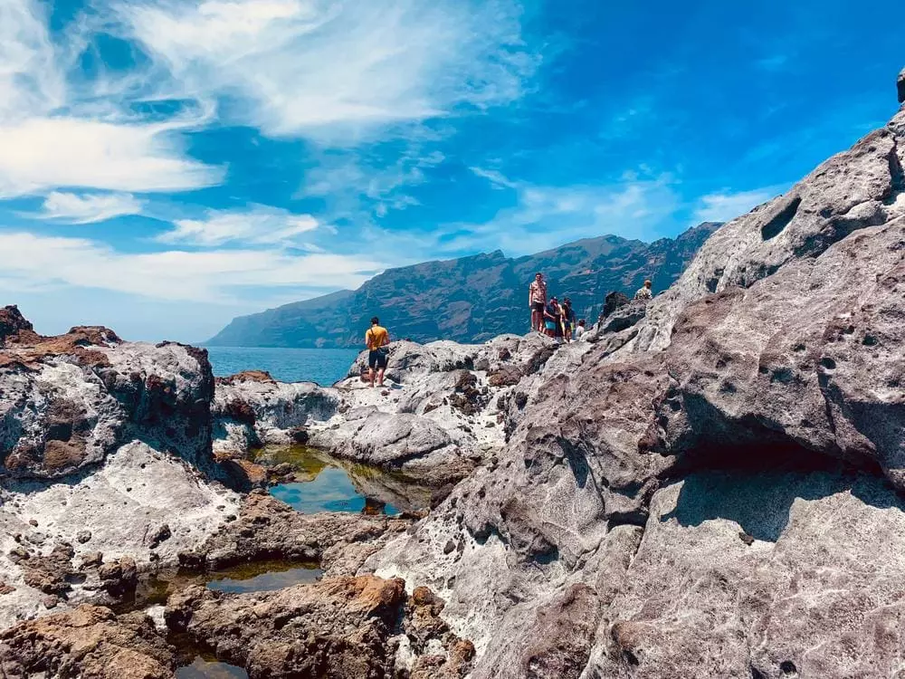 Turister badar vid klippor